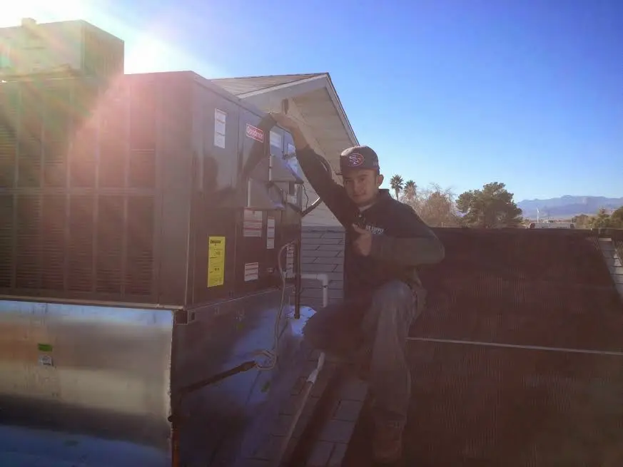 HVAC technician performing Air Duct Cleaning on a rooftop unit in Elkridge
